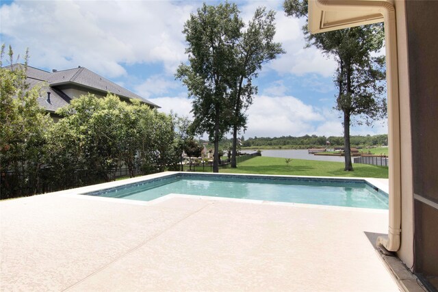 view of pool with a lawn, a water view, and a patio