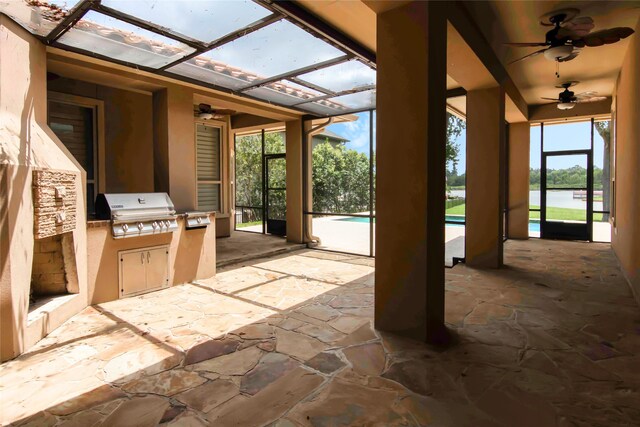 view of patio with area for grilling, a lanai, and ceiling fan