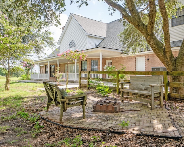 back of property featuring a porch and a fire pit