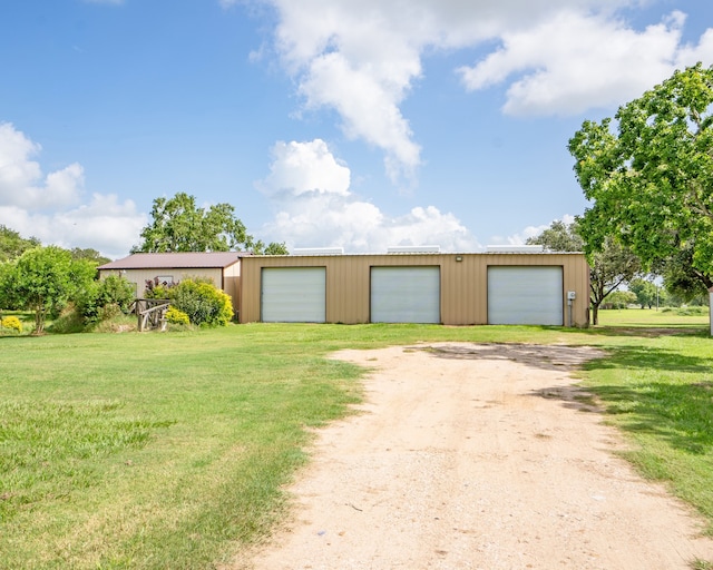 single story home with a garage, an outdoor structure, and a front yard