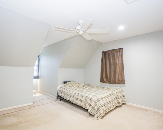 bedroom with light colored carpet, vaulted ceiling, and baseboards