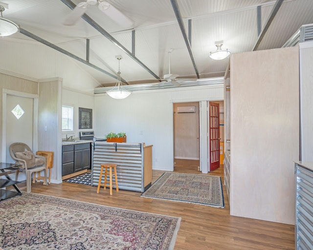 kitchen with a wall unit AC, decorative light fixtures, beam ceiling, a ceiling fan, and wood finished floors