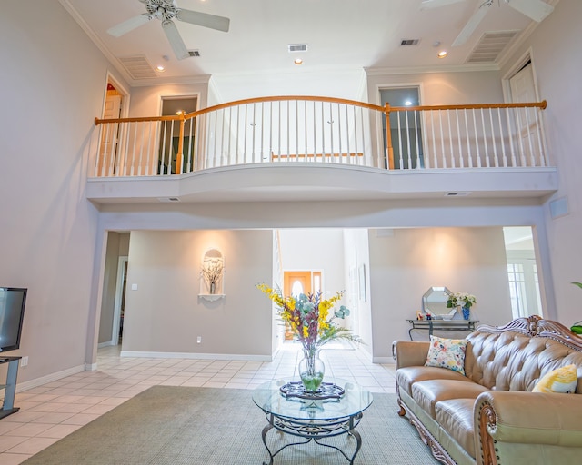 tiled living room with a high ceiling, ceiling fan, and ornamental molding