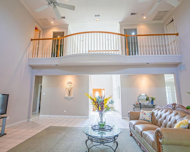 tiled living area featuring ceiling fan, visible vents, ornamental molding, and a towering ceiling