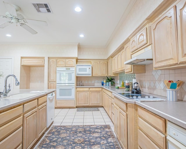 kitchen with white appliances, light brown cabinetry, under cabinet range hood, a sink, and visible vents