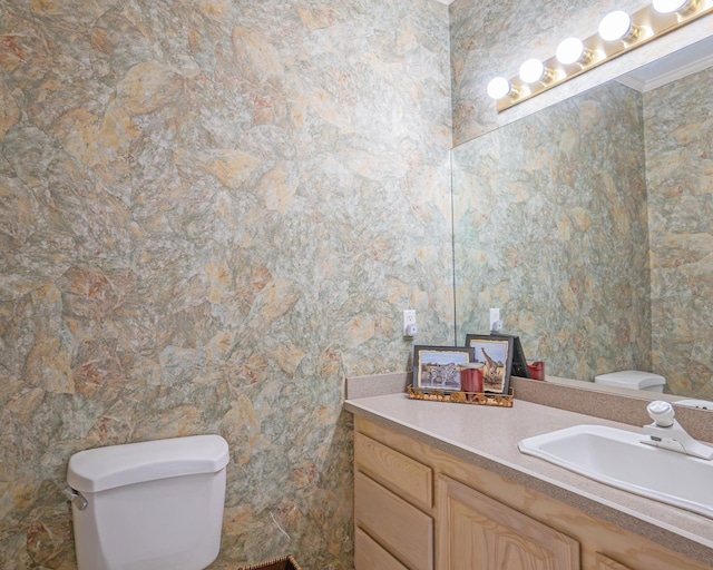 half bath with toilet, vanity, and ornamental molding