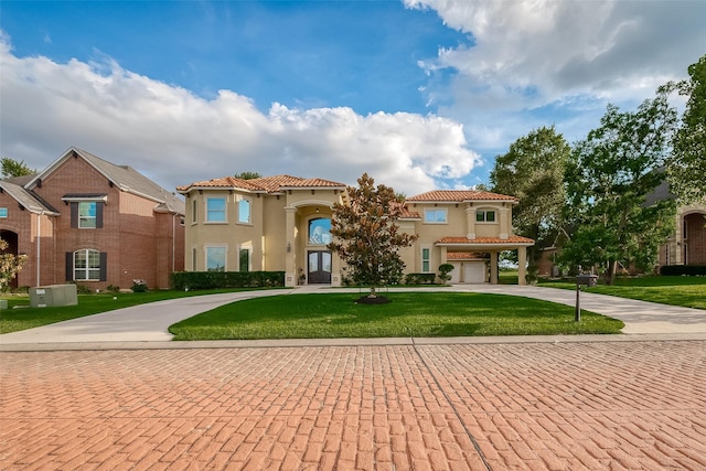 mediterranean / spanish-style house featuring a garage and a front lawn