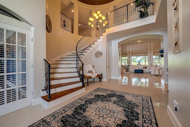 tiled foyer entrance with a towering ceiling and a chandelier