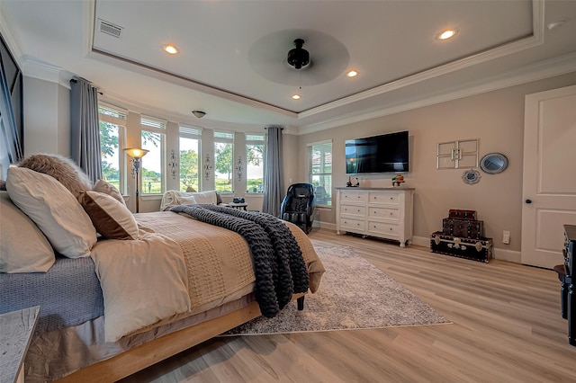 bedroom with a raised ceiling, ornamental molding, ceiling fan, and light hardwood / wood-style flooring