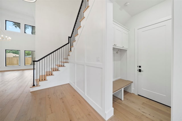 mudroom with light wood-type flooring and a chandelier