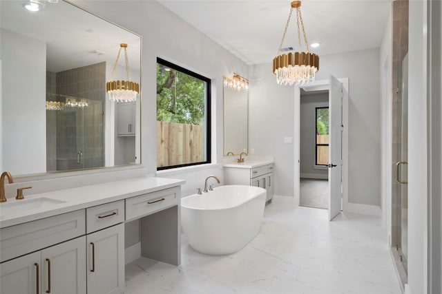 bathroom with vanity, independent shower and bath, and a chandelier