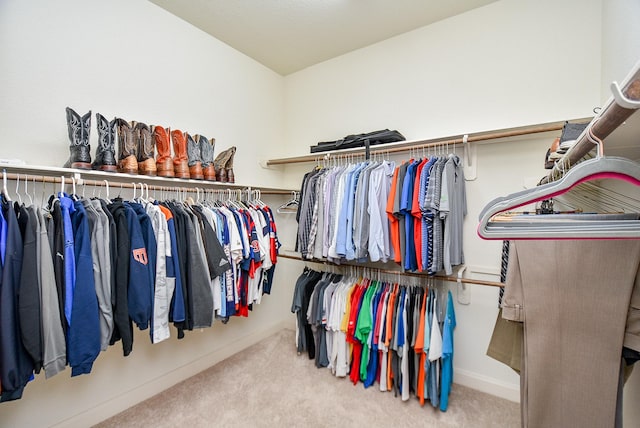 walk in closet with light colored carpet