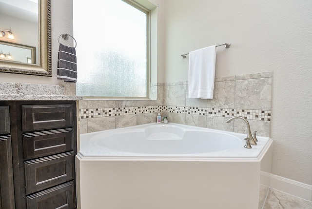 bathroom featuring a washtub and vanity