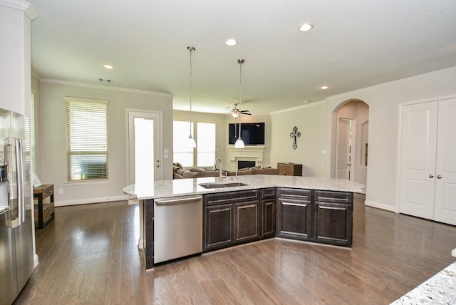 kitchen featuring dark brown cabinetry, ceiling fan, sink, a kitchen island with sink, and appliances with stainless steel finishes