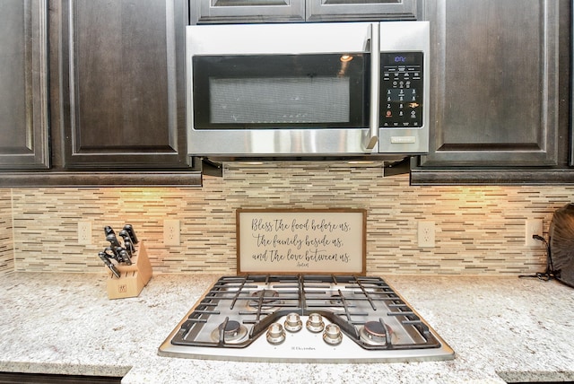 kitchen featuring decorative backsplash, appliances with stainless steel finishes, and dark brown cabinetry