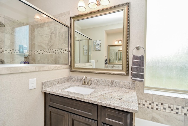 bathroom featuring crown molding, vanity, and tiled shower