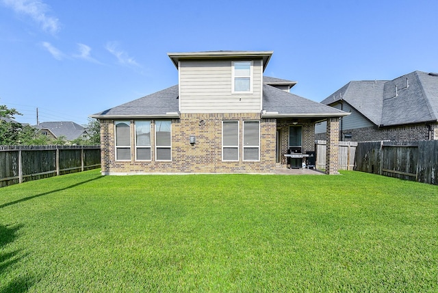 back of house featuring a lawn and a patio area