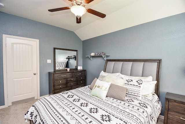 carpeted bedroom with ceiling fan and vaulted ceiling