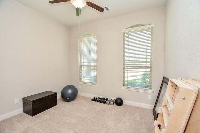 workout area with ceiling fan and light carpet