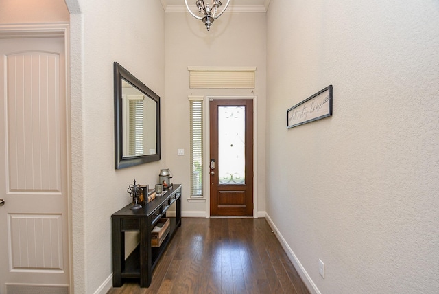 foyer entrance featuring dark hardwood / wood-style floors, an inviting chandelier, and crown molding