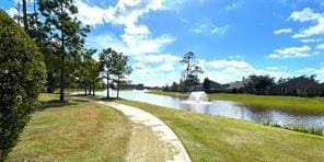 surrounding community featuring a water view and a lawn