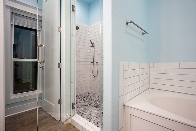 1295 Lagoon Dr, Crystal Beach, TX 77650 - bathroom with a stall shower, a bath, and wood finished floors