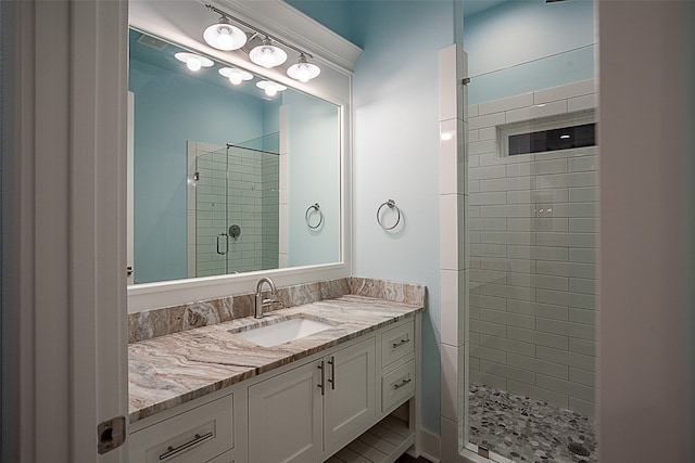 bathroom featuring tiled shower and vanity