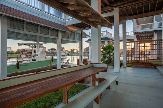 patio terrace at dusk with a balcony and a water view