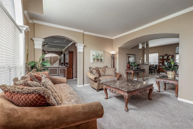 carpeted living room with a textured ceiling, decorative columns, and crown molding