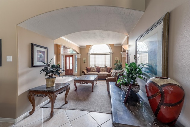 living room with ornamental molding and light tile patterned floors