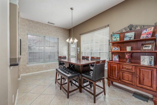 tiled dining space with a chandelier