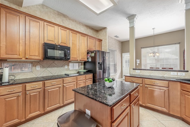 kitchen with ornate columns, a chandelier, pendant lighting, a kitchen island, and black appliances