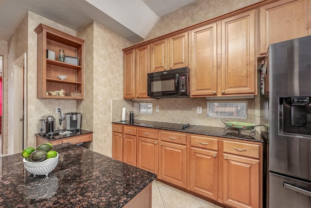 kitchen featuring dark stone counters, light tile patterned floors, black appliances, and vaulted ceiling