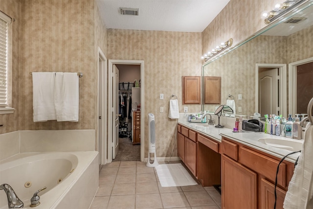 bathroom featuring tile patterned flooring, vanity, a bathtub, and a textured ceiling