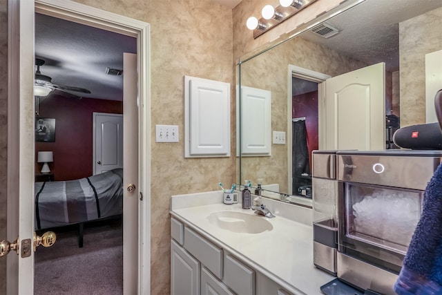 bathroom with vanity, a textured ceiling, and ceiling fan