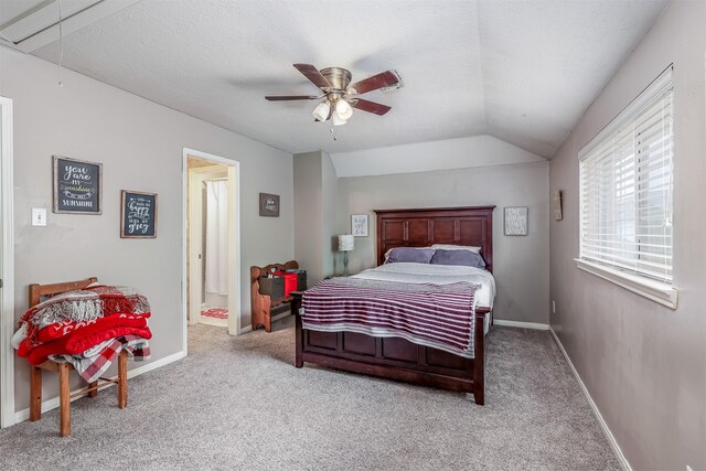 bedroom featuring ensuite bath, ceiling fan, a textured ceiling, lofted ceiling, and light carpet