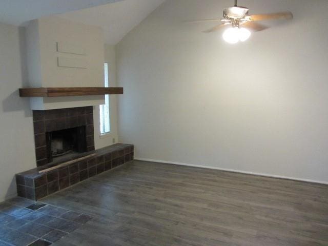 unfurnished living room with ceiling fan, lofted ceiling, a fireplace, and dark hardwood / wood-style flooring