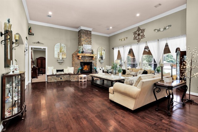 living room with hardwood / wood-style flooring, ornamental molding, and a stone fireplace