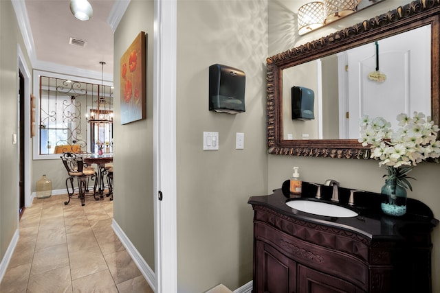 bathroom featuring baseboards, visible vents, ornamental molding, and vanity