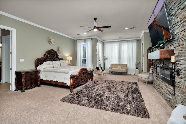 bedroom with crown molding, ceiling fan, a fireplace, and light colored carpet