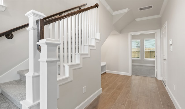 stairway featuring hardwood / wood-style floors and ornamental molding