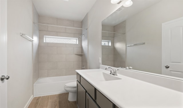 full bathroom with vanity, tiled shower / bath combo, hardwood / wood-style flooring, and toilet