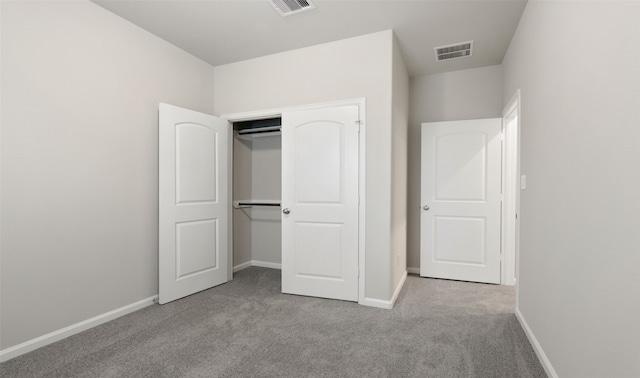 unfurnished bedroom with a closet and light colored carpet