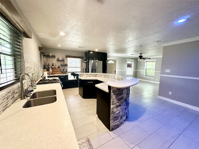 kitchen featuring ceiling fan, light tile patterned floors, sink, stainless steel fridge with ice dispenser, and a textured ceiling