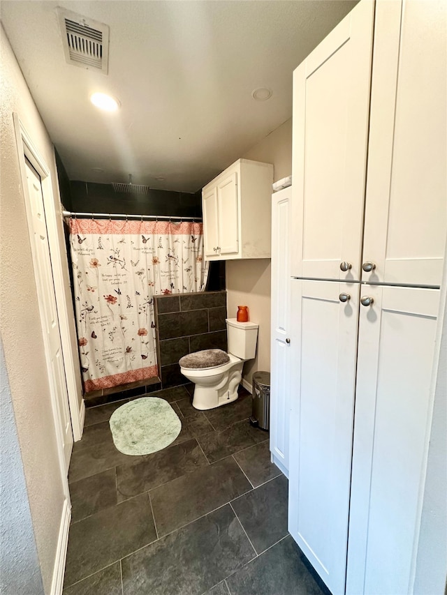 bathroom with tile patterned flooring, toilet, and a shower with curtain