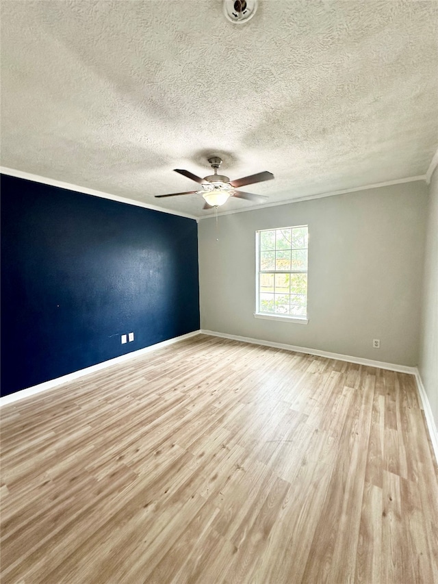 spare room featuring a textured ceiling, ceiling fan, light hardwood / wood-style floors, and ornamental molding