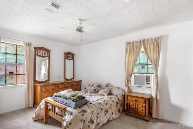 bedroom featuring ceiling fan, light carpet, and a textured ceiling