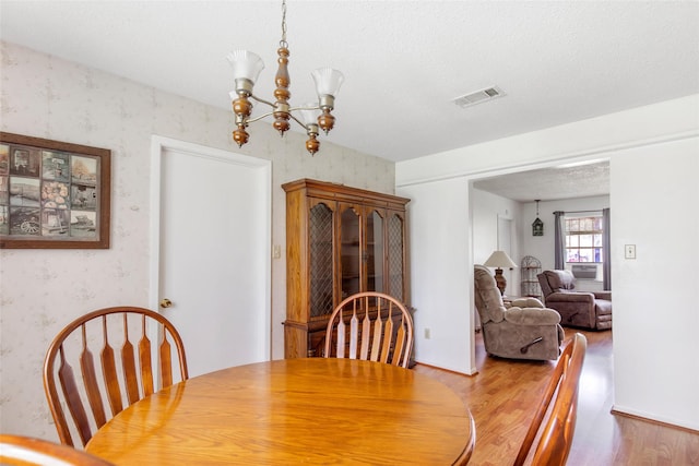 dining room featuring a chandelier, a textured ceiling, and hardwood / wood-style flooring