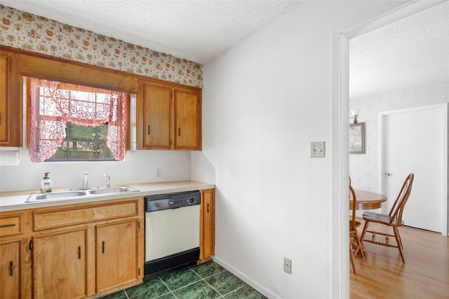 kitchen featuring dishwasher, a textured ceiling, and sink