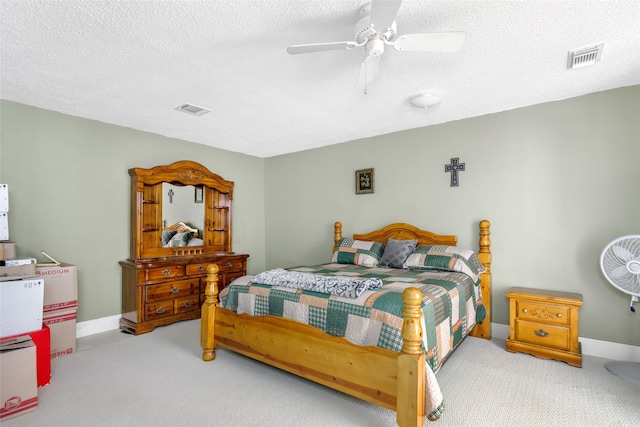 carpeted bedroom with ceiling fan and a textured ceiling